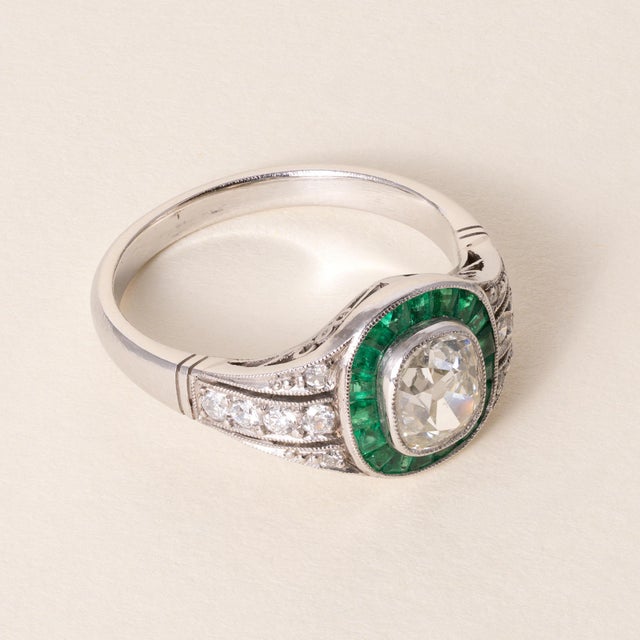 Art Deco Old Mine Cut Diamond & Emerald Halo Ring in Platinum Circa 1920 An exquisite example of early Art Deco...