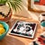 A 1992 handmade ceramic tile, decorated with a 90's tribal design depicting musicians. It has a hole for hanging, and a...