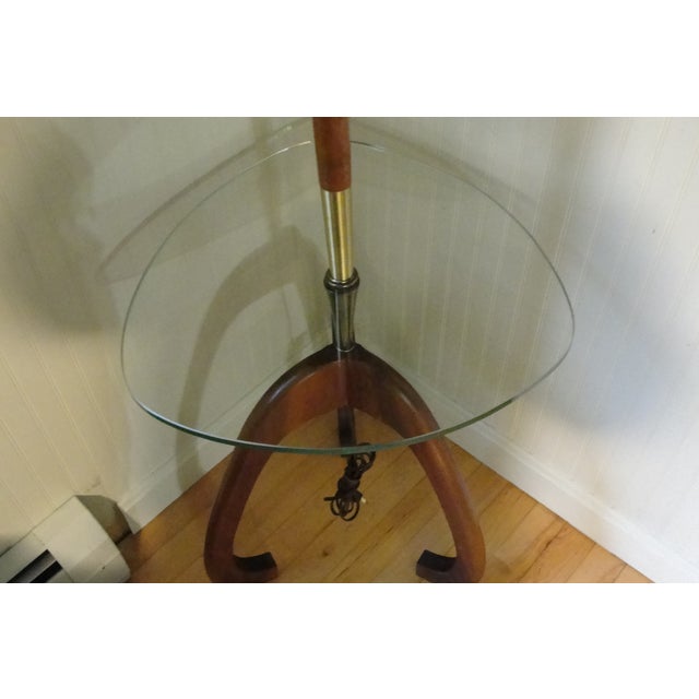 Impeccable Mid Century Mod Modeline? Walnut and Glass floor lamp table combination. This sculptural table is a three leg...