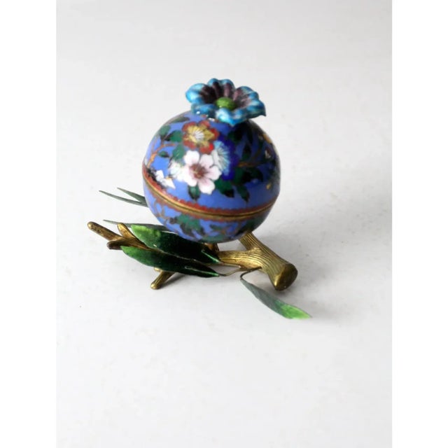 A rare antique cloisonné sculptural box featuring a round enamel and brass container that nests atop a brass branch...