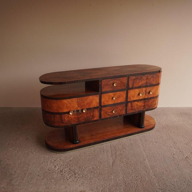 Architectural Art Deco sideboard in bookmatched walnut burl with bold Macassar ebony banding throughout. The body has two...