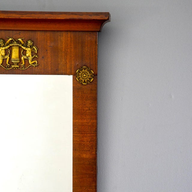 English empire style mirror has a mahogany frame with decorative pediment and Ormolu mounts, circa 1880s. Actual mirror...