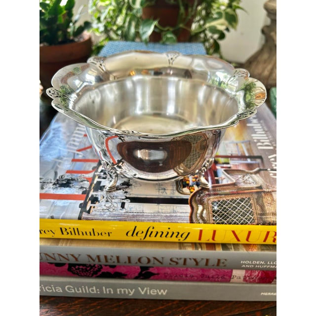 This scalloped footed bowl has the Art Deco look of the early 20th century. Made by Wm Rogers of silver plate over copper,...