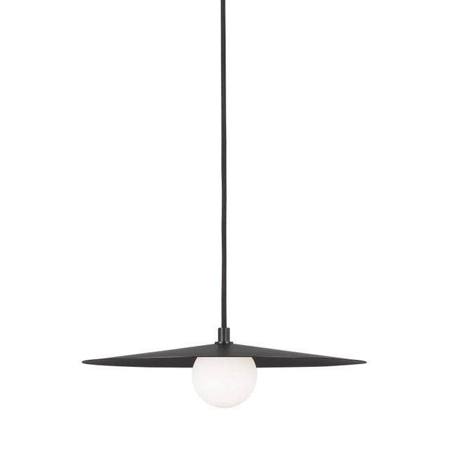 The Pirlo pendant by Sean Lavin for Tech Lighting contrasts a flattened metal shade with a frosted glass globe, creating...