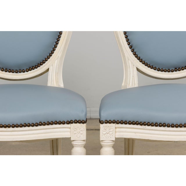 A refined set of six early 20th century French Louis XVI dining chairs sourced in Paris, consisting of four side chairs...