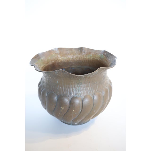 A trumpeted brass hand hammered planter is a stunning decorative container crafted from brass. This planter features a...