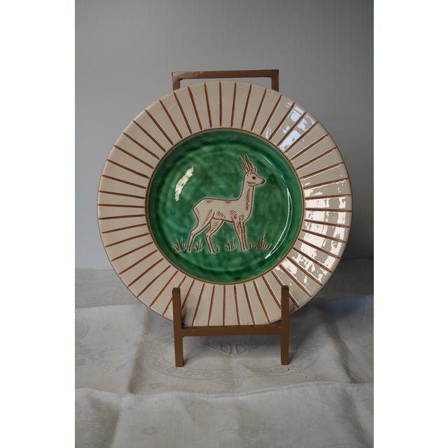 A small glazed ceramic dish from Haunsø Ceramics, Denmark, made in the 1950s. Cream-white ground with bright green glaze,...
