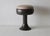 Vintage Space Age tulip-style pedestal stool with a dark flared base, an integrated rounded body, and a swiveling...