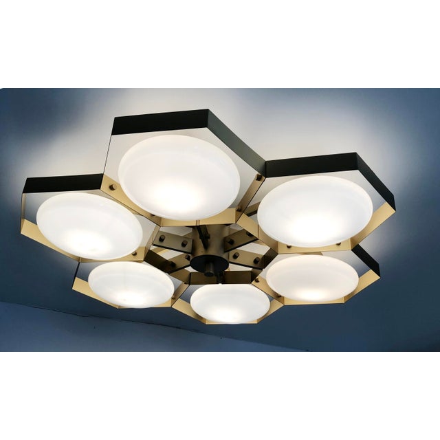 Italian midcentury flush mount with six glossy white Murano glass shades mounted on solid brass frame in satin brass...