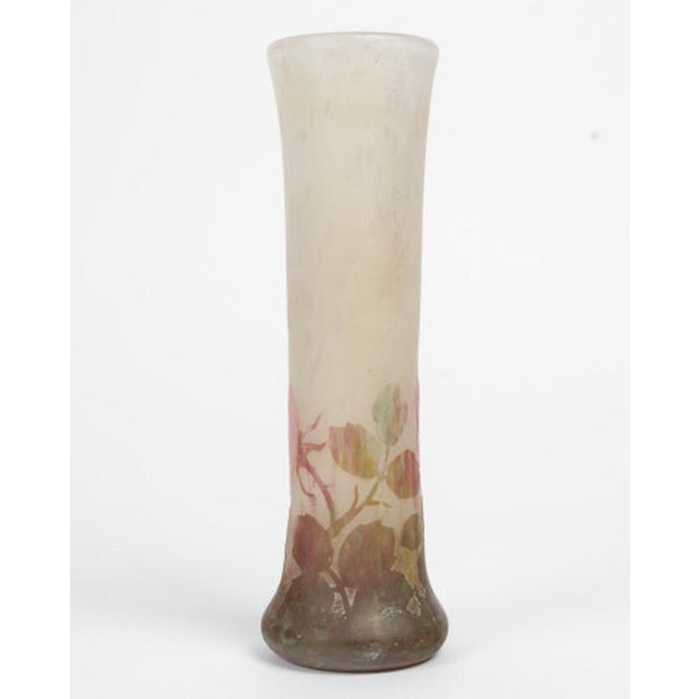 A soliflore-shaped vase with a tapered shape and flared base, decorated with stems and leaves highlighted with vitrifying...