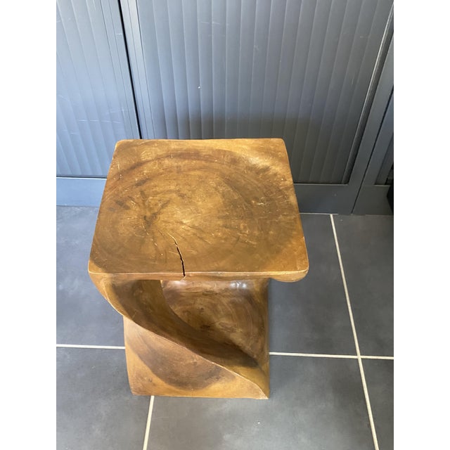 Made of solid walnut, carved from a single piece of wood. There are a few cracks, but the stool is perfectly stable and...