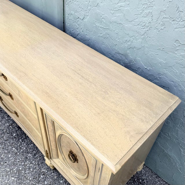 Elegant vintage French Provincial dresser by Detroit Furniture, featuring a softly distressed cream finish accented by...