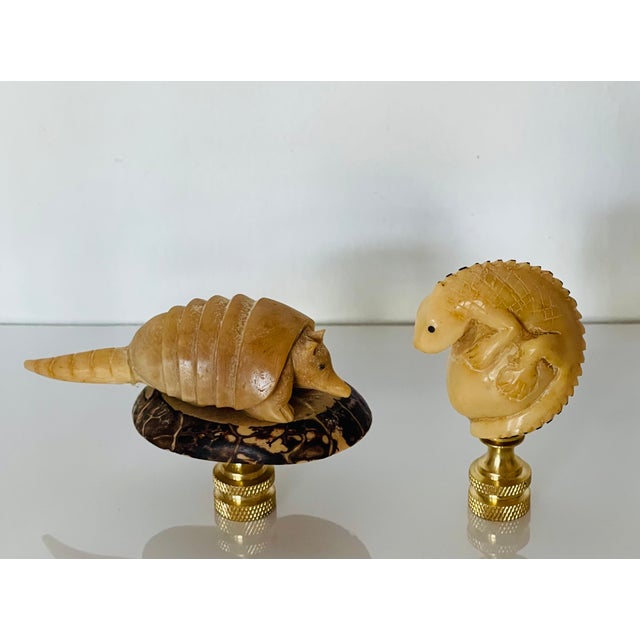 Two vintage Florida animalistic figurines of armadillo and iguana mounted on brass bases as lamp finials.