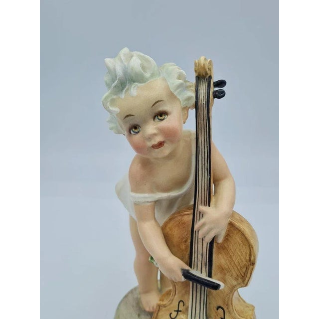 Arturo Pannunzio (1891-1953), "little girl with cello", ceramic figurine. Born in Campobasso in 1891, Arturo Pannunzio...