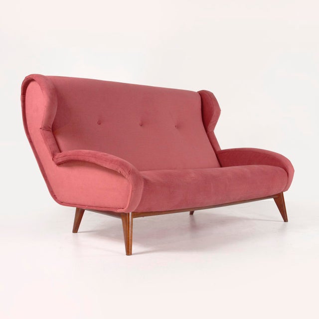 1960s Italian-made sofa. Healthy padding and solid walnut legs. New dark pink fabric upholstery.