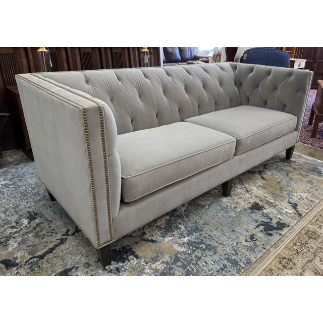 This Stickley Draper Sofa is upholstered in a versatile greige fabric with deep button tufting across the back and arms...