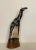 The solid wood giraffe is carved from a single piece of wood. Painted in neutral tones of black, various shades of gray...