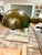 A beautifully aged vintage adjustable floor lamp featuring a sculptural dome shade, warm patinated brass finish, and white...