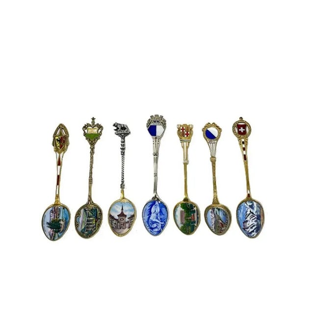 A set of 7 Silver and enamel spoons from various places in Europe. Silver 800 gold plated * Liberte et Patrie, scene of...