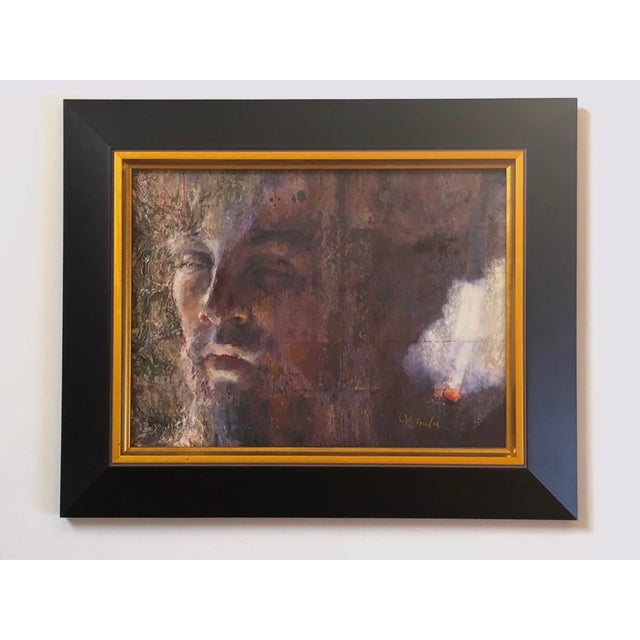 This oil on collage work presents a contemplative face emerging from a textured background, where vibrant hues interplay...