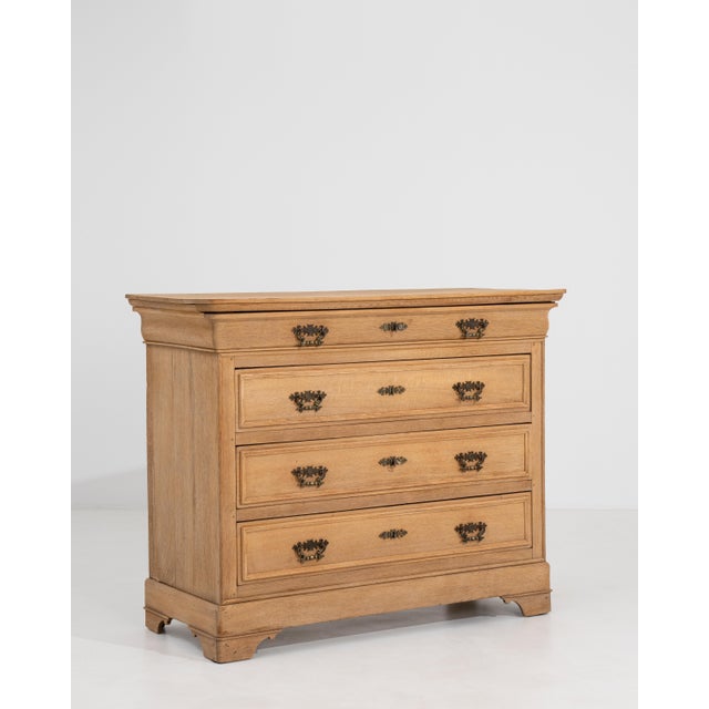 A French oak chest of drawers with a simple, structured form. The piece features multiple storage drawers set within a...