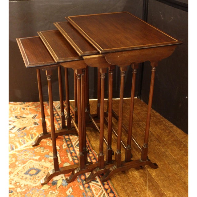 Quartet of nesting tables, circa 1880, English. Mahogany in the George III taste. Raised on arched bases with elegantly...