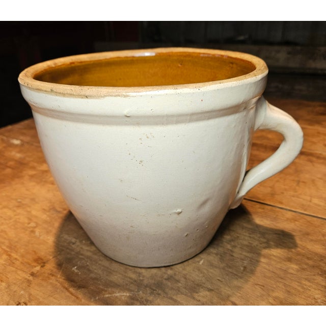 This vintage French stoneware crock pot features the word MERGERE penciled on the bottom along with the number 1344....