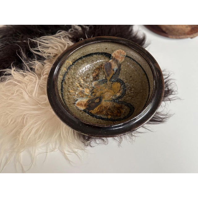 This is a large 12” artisan stoneware bowl, signed by the artist who is unknown. It has a nice depth and a bold rim with...