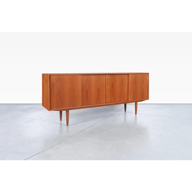Designed by Axel Christensen for ACO Mobler in Denmark during the 1960s, this Danish modern teak credenza exemplifies the...