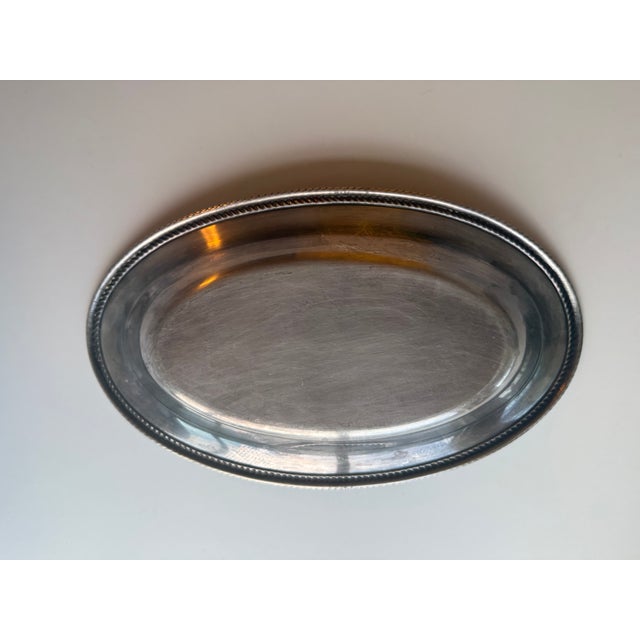 This mid-20th century silver plated oval bread tray by Wm. A Rogers is a classic piece with a gadroon tight rope edge...