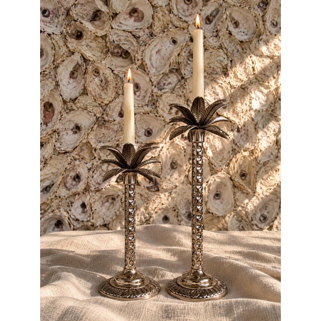 A striking pair of palm tree candlestick holders by Andrea by Sadek, featuring sculptural palm frond tops, elegantly...