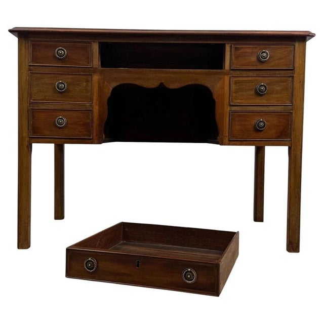 An elegant early 20th-century English writing table, finely crafted from mahogany and distinguished by its seven-drawer...