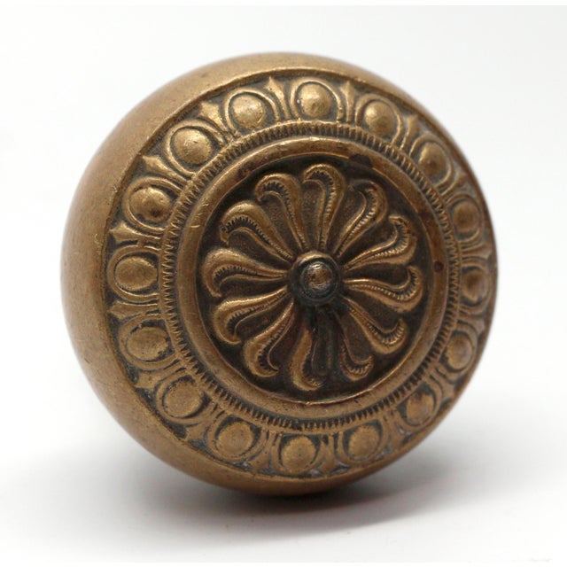 Gothic style concentric knob with egg & dart trim and floral center details. Made by Chicago Hardware in the 1905 catalog....