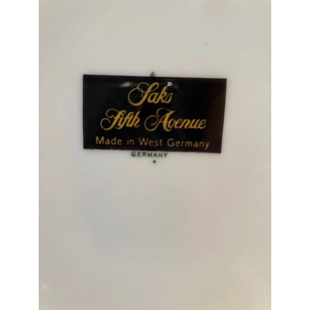 Elevate your dining presentation with this rare and stylish set of four vintage porcelain dinner plates from Saks Fifth...