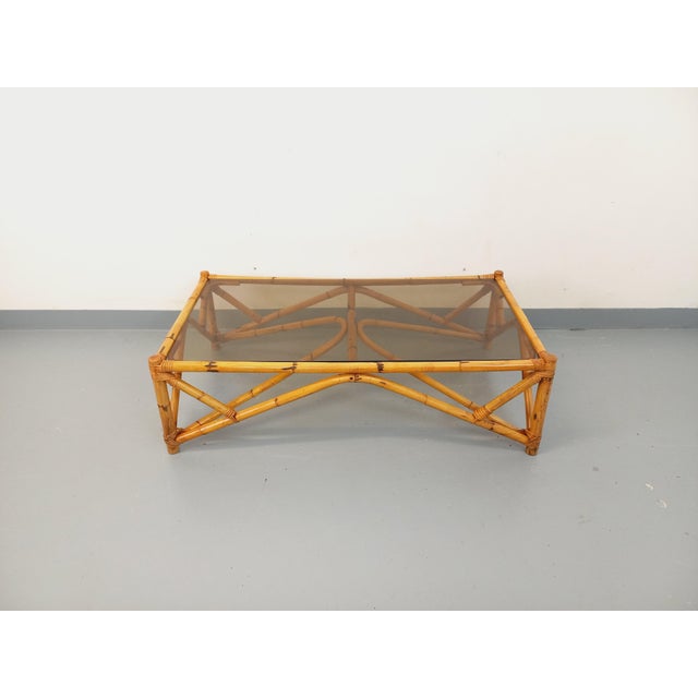 Large vintage coffee table from the 1970s, made of rattan, with a rectangular smoked glass top. In very good overall...