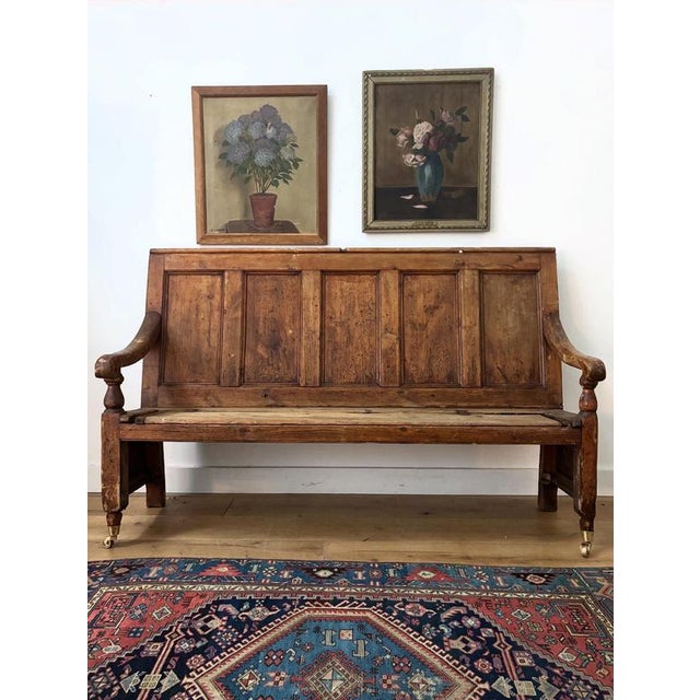 A fabulously unique panelled 18th century hallway bench. This has been loved over the years, with the wood on the arm...