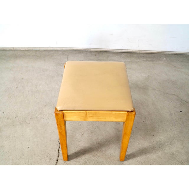 Vintage Mid century Modern piano bench / stool for sale. It's made of solid birch in a natural birch finish, and has a tan...