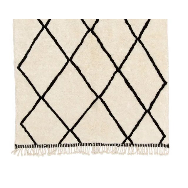 Hand-knotted wool rug showcasing a timeless Ivory foundation adorned with Midnight black diamond patterns, offering...