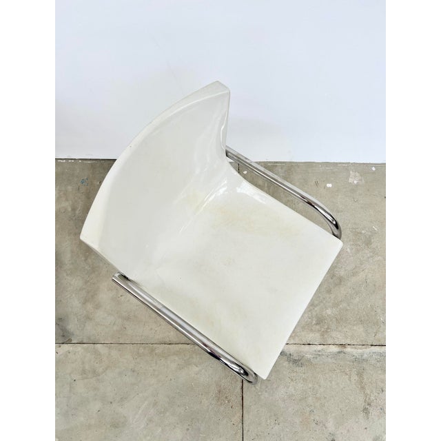 Pair of white molded plastic shell chairs on chromed tubular frames, in a 1970s-80s Space Age style. Chromed frame in very...