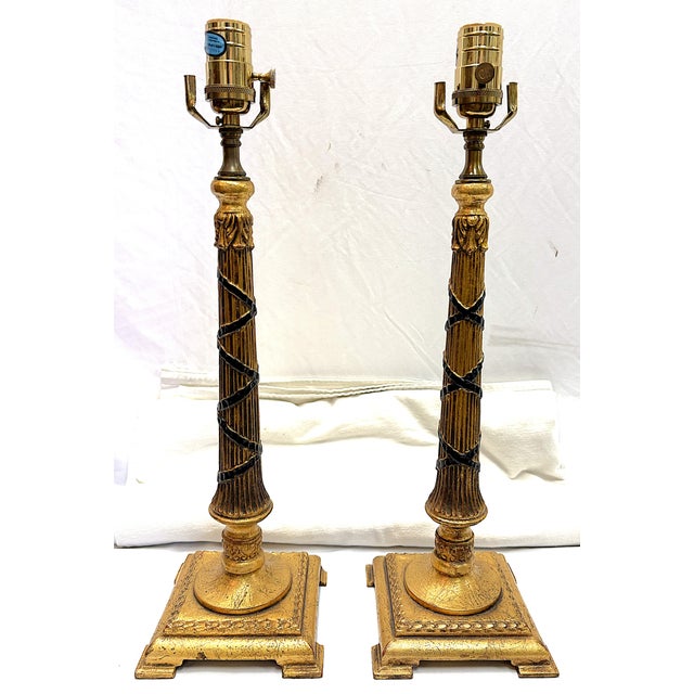 Timeless pair of Hollywood Regency style candlestick lamps from the late 20th century. They're made of a composite...
