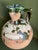 Country pottery terracotta jug with Fiancé color green splatter glaze and concentric circle design around the top of the...