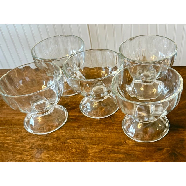 This is a set of five charming vintage dessert bowls featuring a ribbed or optic pattern on their side with a footed base....