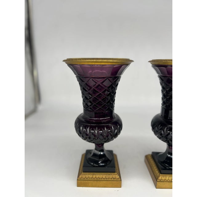 An incredibly fine pair of antique Amethyst cut crystal vases mounted with dore bronze mounts. The vases have delicate...