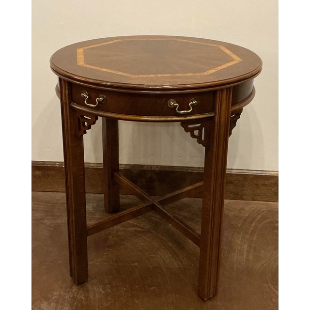 Late 20th C table has a central pullout drawer decorated with traditional brass batwing style pulls. The legs are straight...