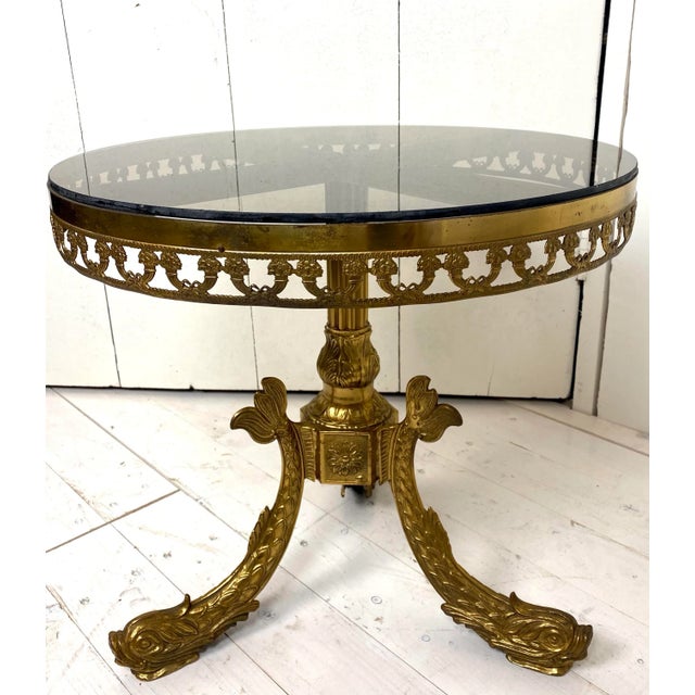 Round brass Regency coffee-table on a base of three nicely detailed koi-karper fishes. The edge is richly decorated with...