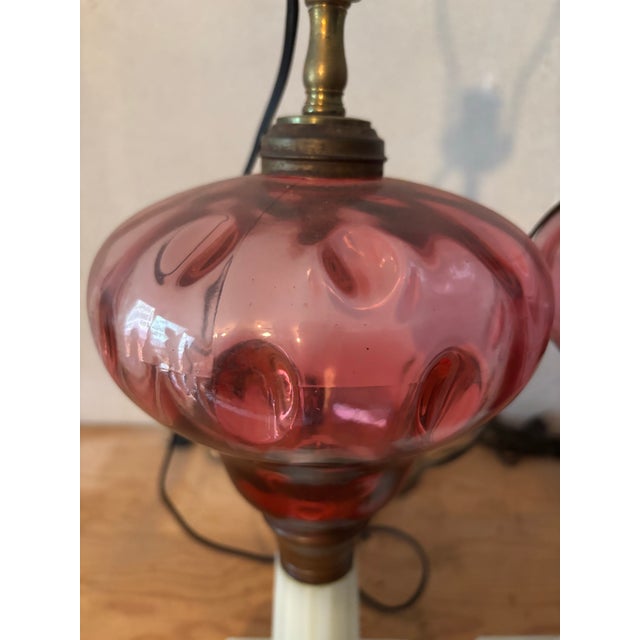 Pair of 19th century milk glass base electrified oil lamps with cranberry thumbprint fonts.