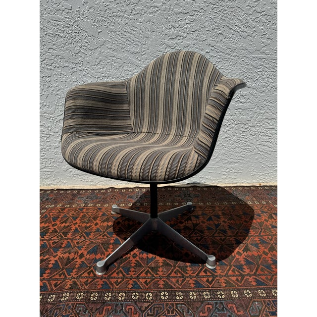 This Mid-Century Eames PAC-1 Armshell Chair by Herman Miller, designed by Charles and Ray Eames, features the distinctive...