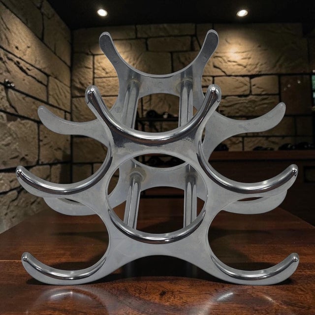 The Eichholtz Alboran Attributed Polished Aluminum 6 Bottle Modern Wine Rack is a sleek and stylish addition to any...