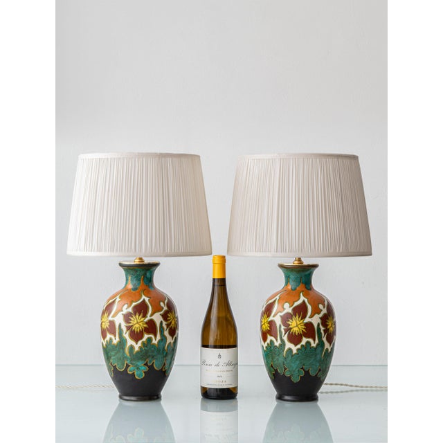 Hand-painted in oxblood red and yellow blooms on an ivory ground, with passages of orange, teal, and black all outlined in...