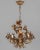 A Hollywood Regency style five-light gilt metal chandelier with tôle lily flowers. Original canopy and chain. Designed by...